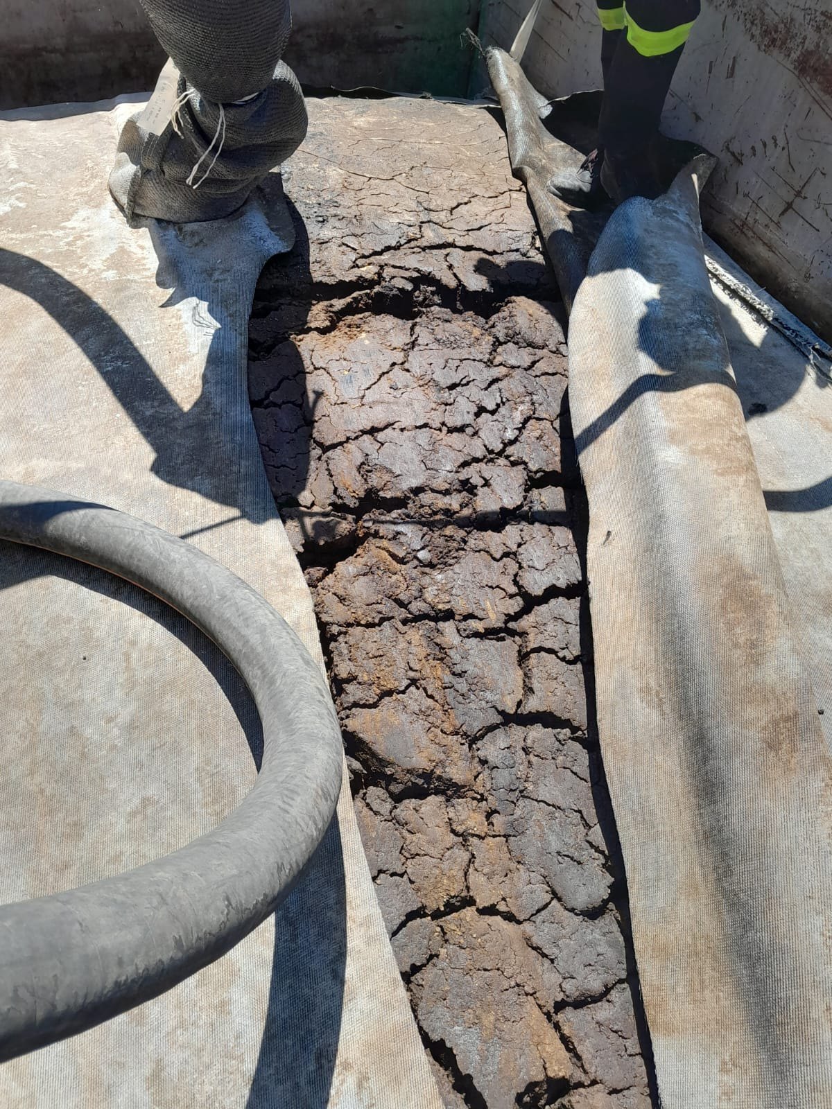 Açılmış geotekstil tüp içindeki kurumuş ve çatlamış katı malzeme.